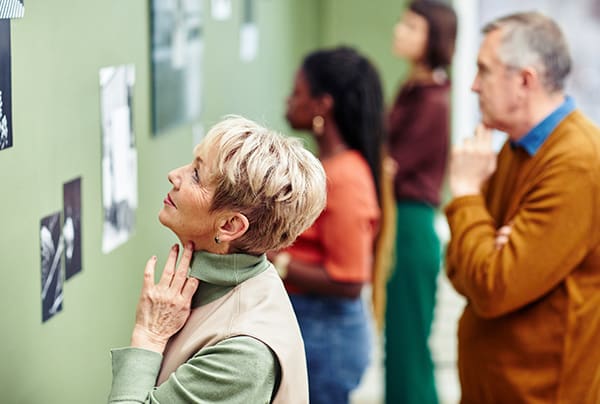 A senior woman and a senior man looking at photography in a gallery